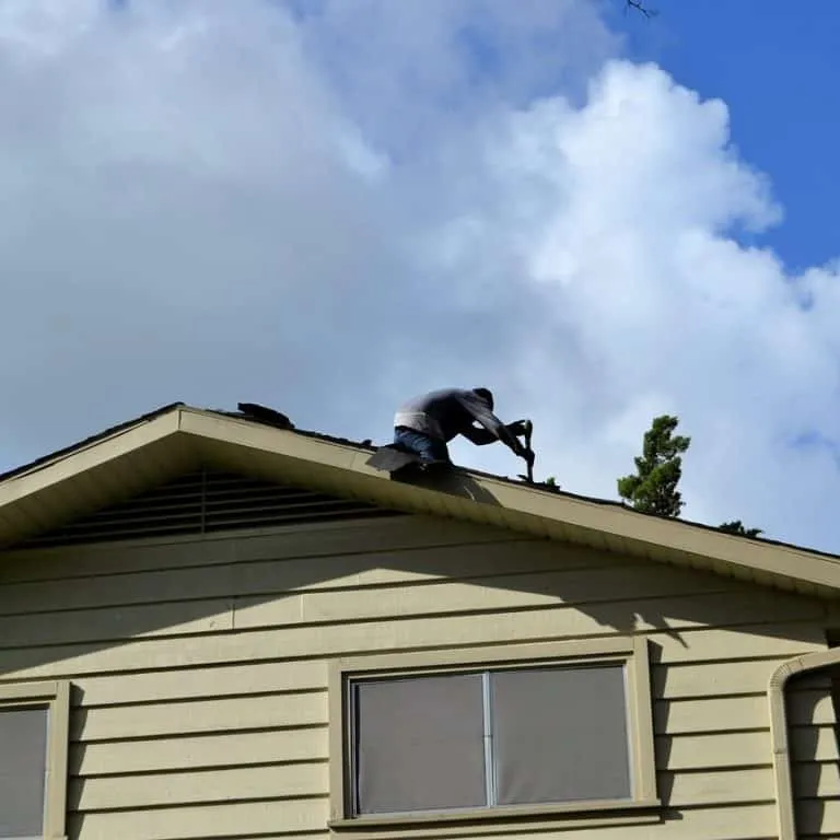 Roofing contractor replacing shingles.